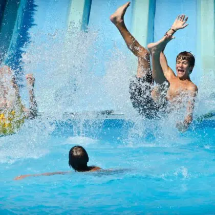 O'gliss park 4 Young people having fun on water slides in aqua park, splashing into swimming pool